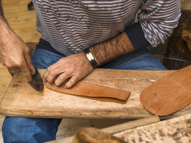 Bőr pontos szabása kézi szerszámmal, közeli felvétel